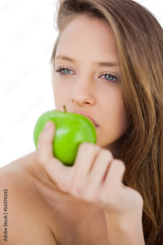 Thoughtful brunette model eating an apple Thoughtful brunette model eating an apple