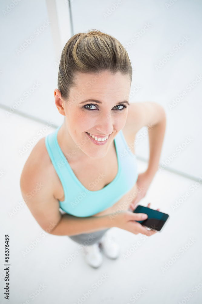 Smiling woman in sportswear using mobile phone Smiling woman in sportswear using mobile phone