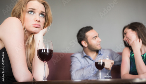 Fotografi Blonde woman feeling jealous of couple flirting beside her