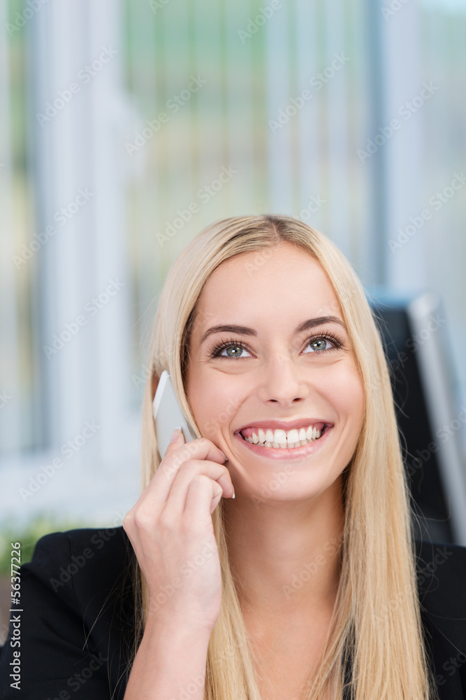 lächelnde junge frau im büro telefoniert mit handy lächelnde junge frau im büro telefoniert mit handy