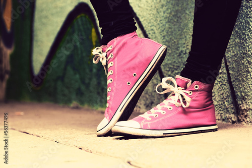 Close up of pink sneakers worn by a teenager.
