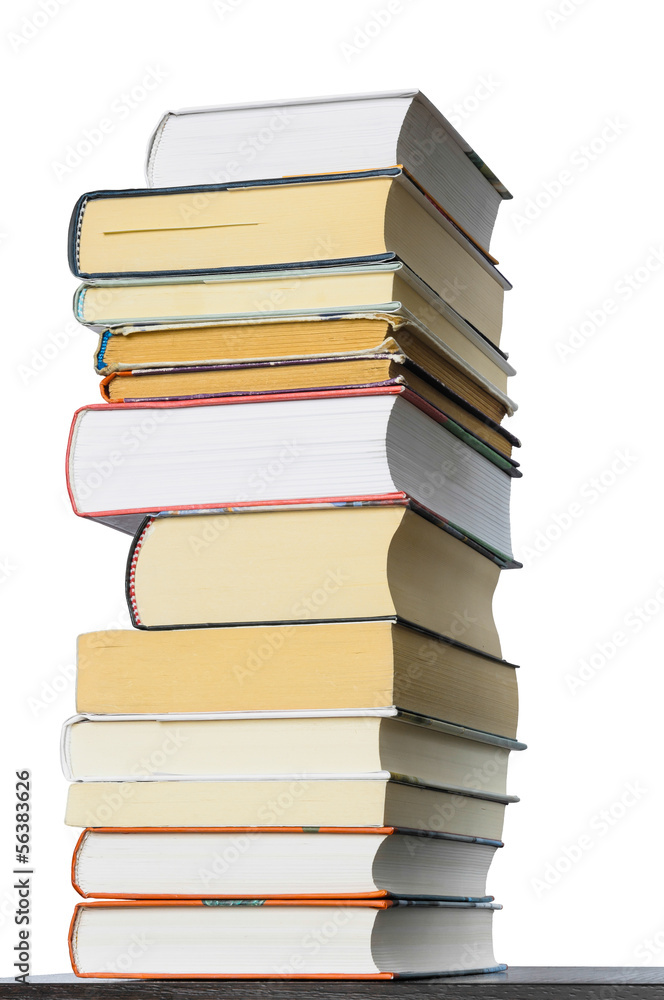 A stack of different books seen from a low point of view, isolated on white background