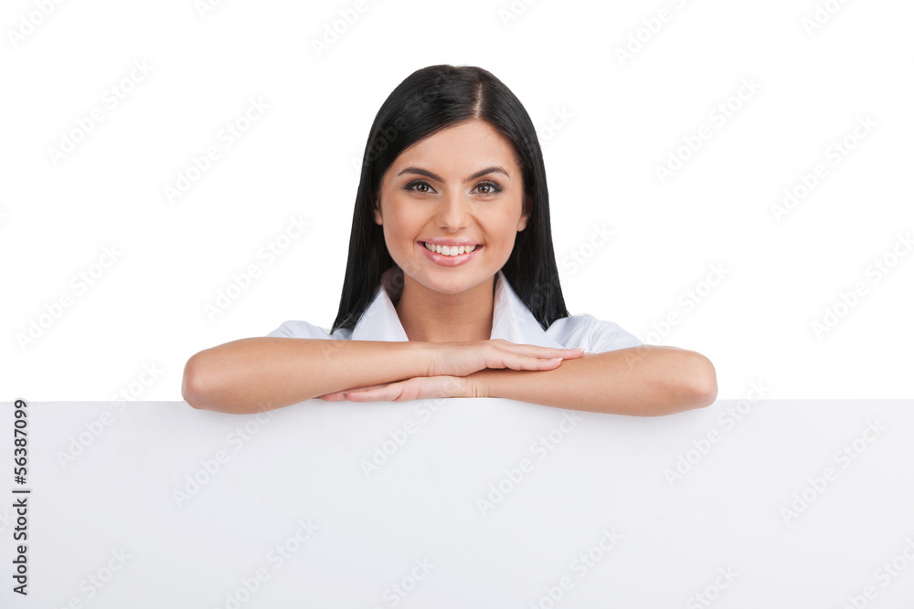 Cheerful woman. Cheerful young woman leaning at poster and looki Cheerful woman. Cheerful young woman leaning at poster and looki