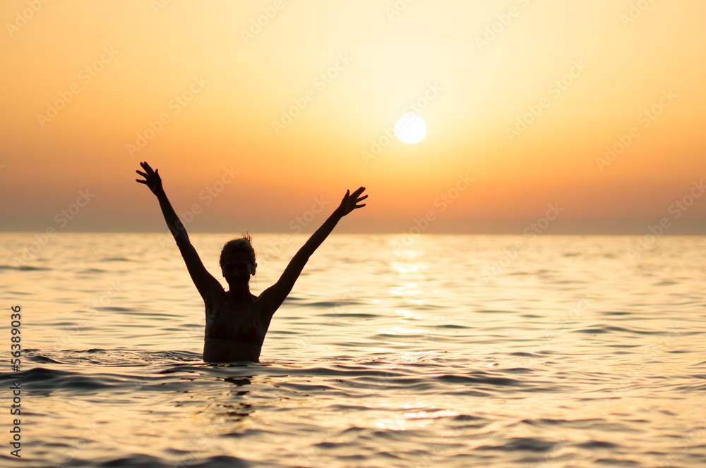 woman swimming at sunset