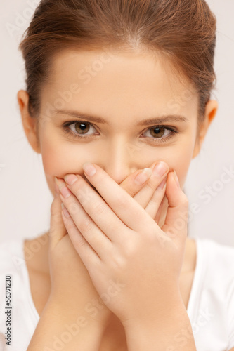 face of beautiful teenage girl covering her mouth