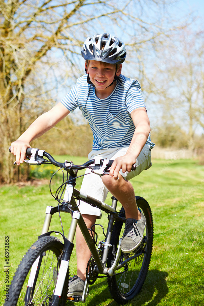 Young Boy Riding Bike Along Country Track Young Boy Riding Bike Along Country Track