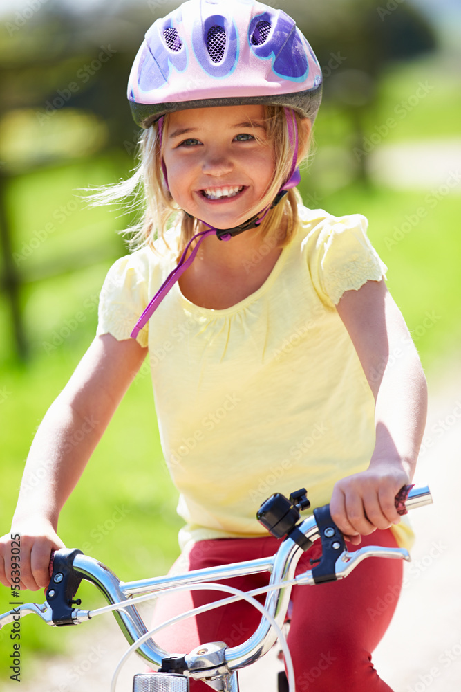 Naklejka premium Young Girl Riding Bike Along Country Track