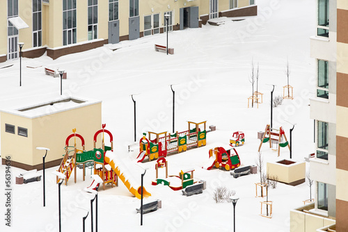Snowy children playground between houses