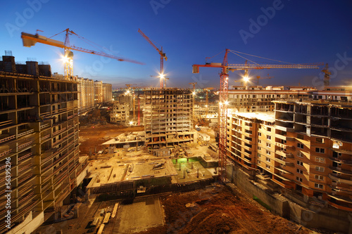 Photography Lots of tower cranes build large residential buildings at night.