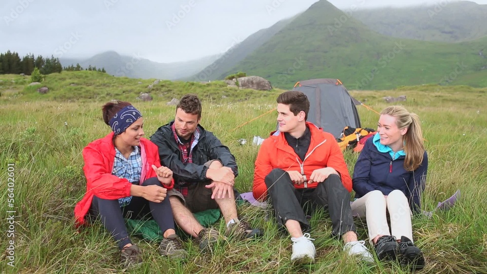 Friends on a camping trip chatting together Friends on a camping trip chatting together