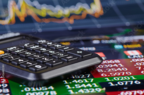 Calculator and financial chart as background. Selective focus