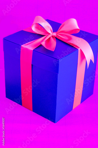 blue present box with red ribbon on pink background © kingjc
