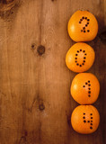 oranges with clove numbers on wooden background