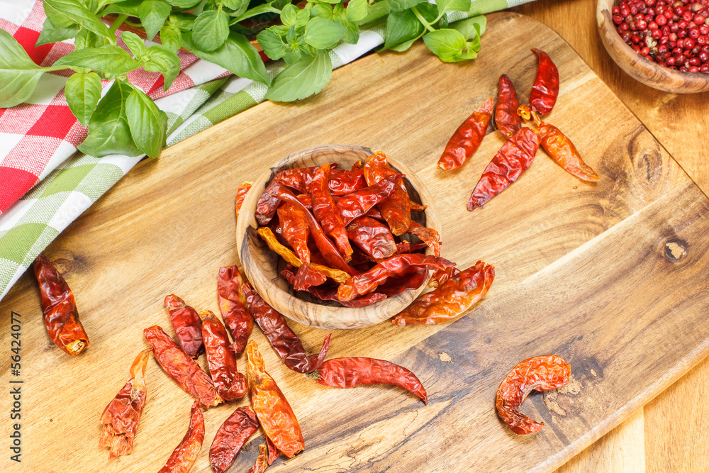 Chili peppers and herbs in olive wood bowls