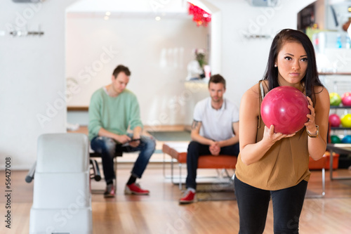 Young Woman Holding Bowling Ball in Club