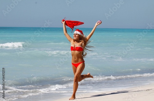 ragazza natalizia corre sulla spiaggia photo