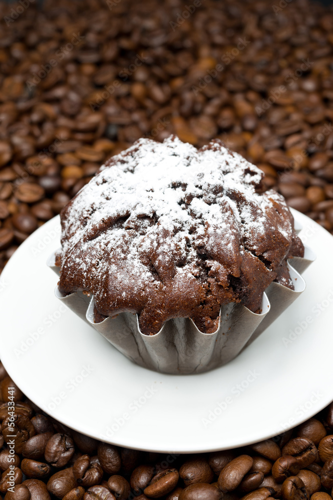 chocolate muffin on a background of coffee beans, close-up chocolate muffin on a background of coffee beans, close-up