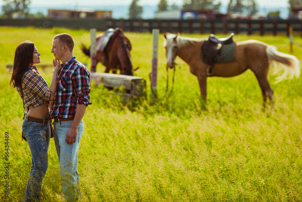 couple standing on farm with horses couple standing on farm with horses