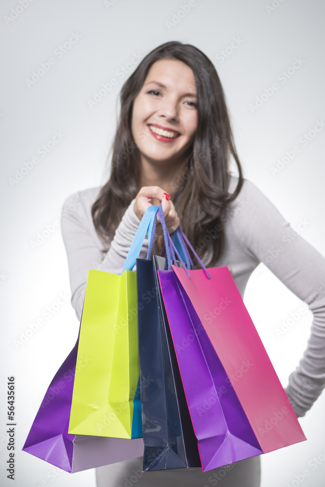 Beautiful satisfied woman holding shopping bags
