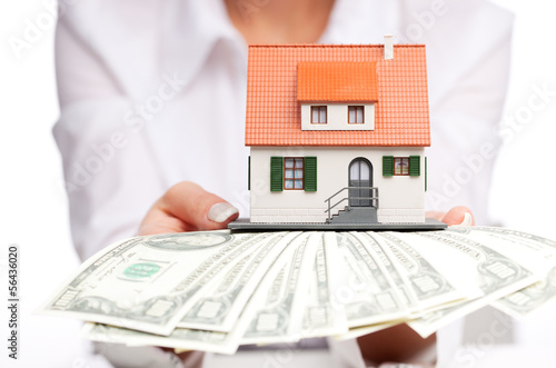 Hands with money and miniature house on a white background photo