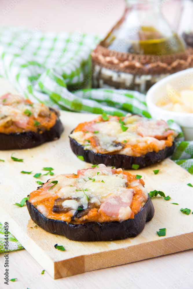 Slice of fried aubergines with tomato, mushrooms, ham and cheese