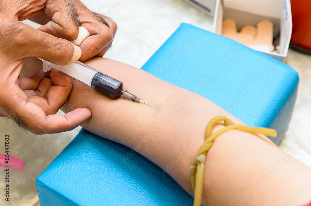 Fototapeta premium The doctor used syringe is taking blood for test