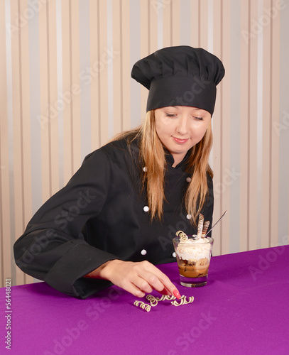 female chef conditer in black tunica decorating tiramisu dessert photo