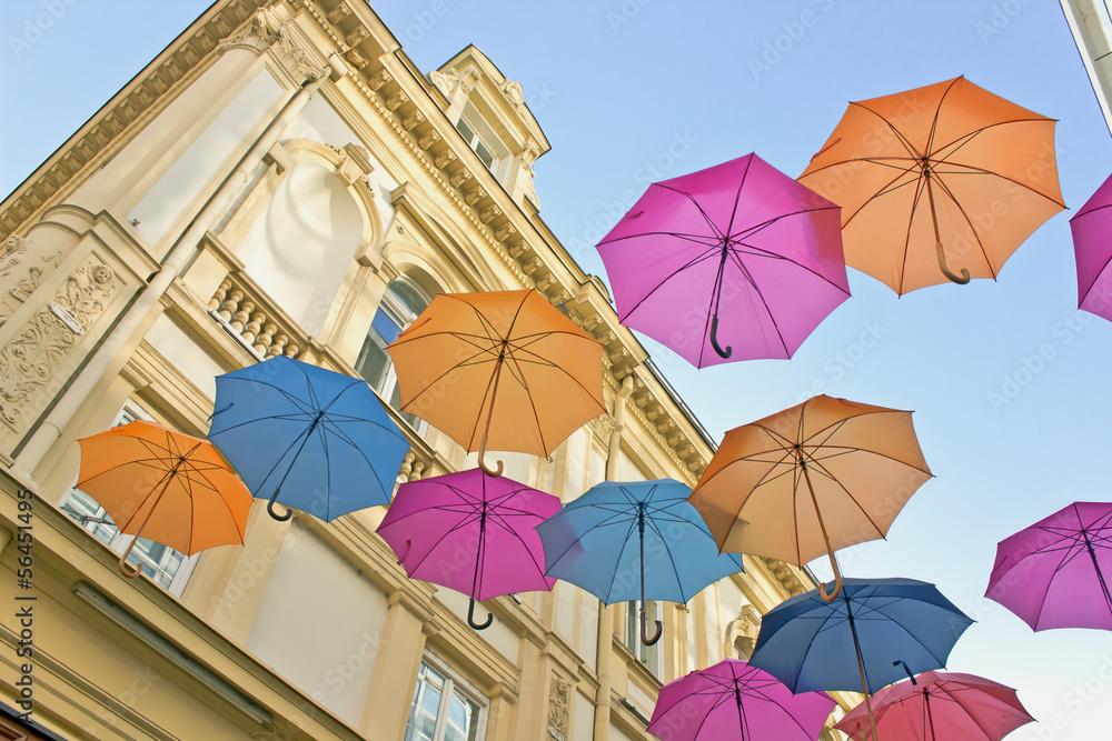 Colorful umbrellas over old building and sky