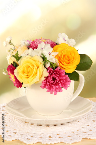 Beautiful bouquet of bright flowers in color mug 