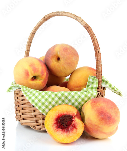 Ripe sweet peaches in wicker basket  isolated on white