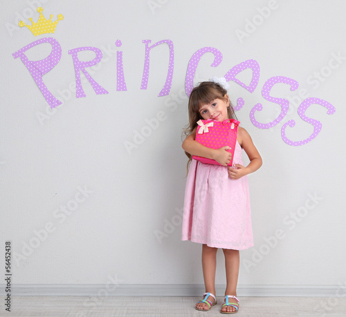 Little girl posing on grey ...
