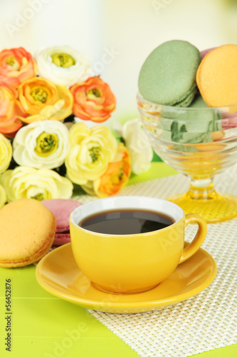 Coffee and macaroons on table on light background