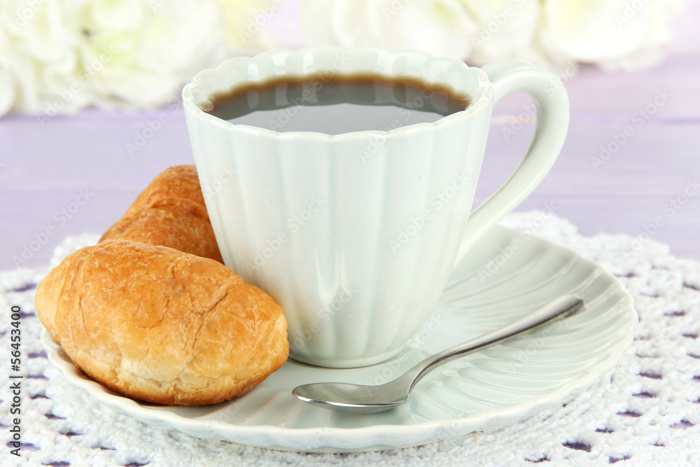 Tasty croissants and cup of coffee on table close-up Tasty croissants and cup of coffee on table close-up