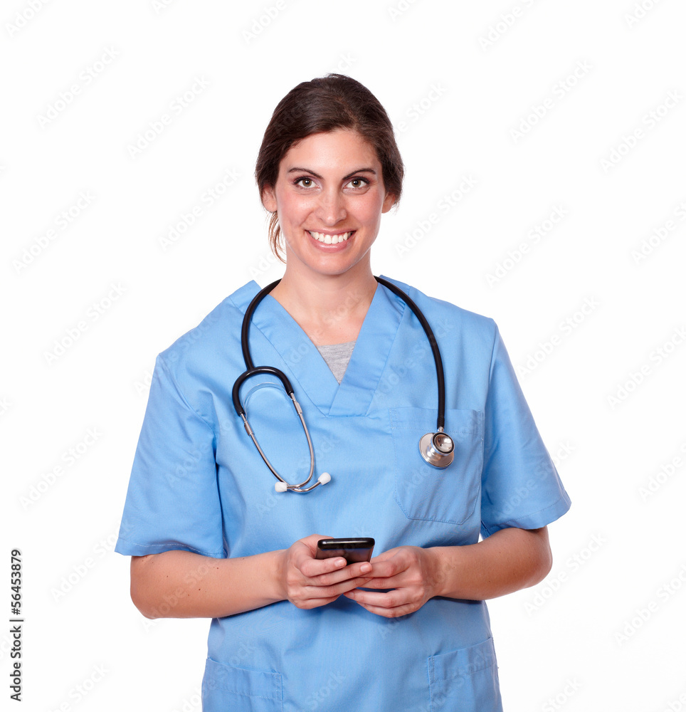 Lovely young nurse smiling sending a text Lovely young nurse smiling sending a text