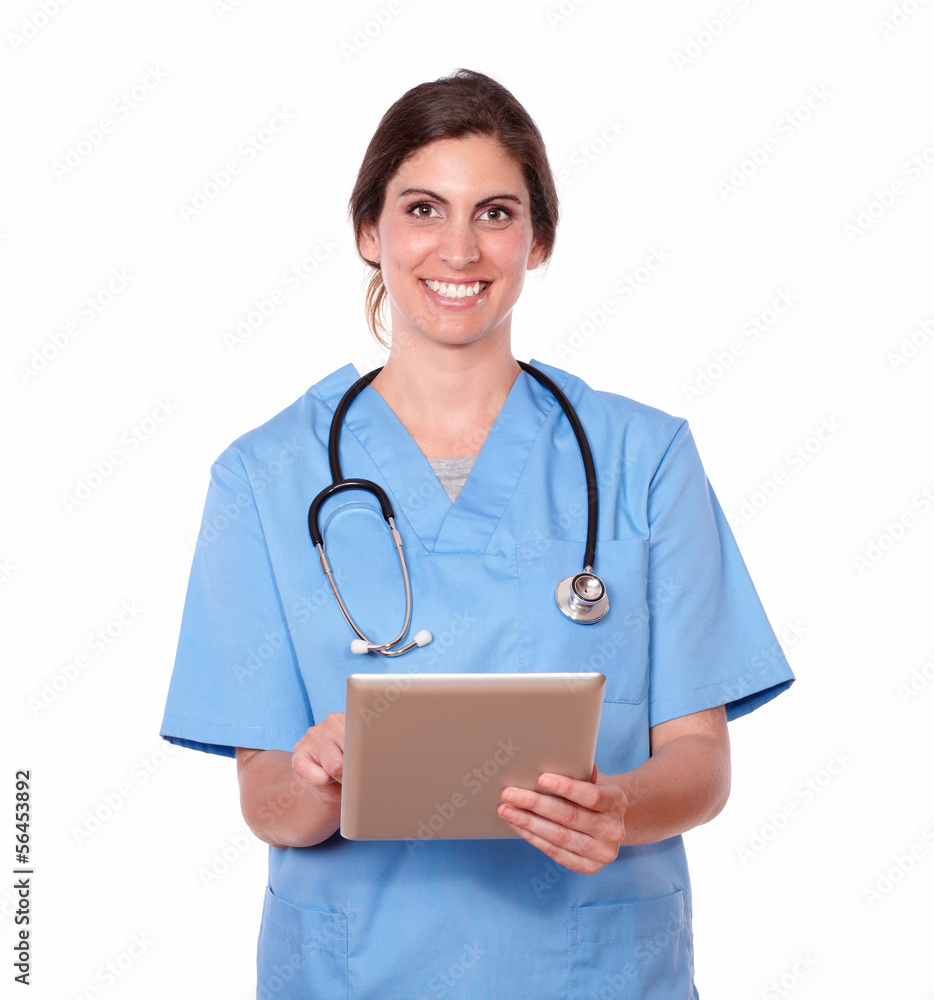 Smiling pretty lady nurse working on tablet pc Smiling pretty lady nurse working on tablet pc