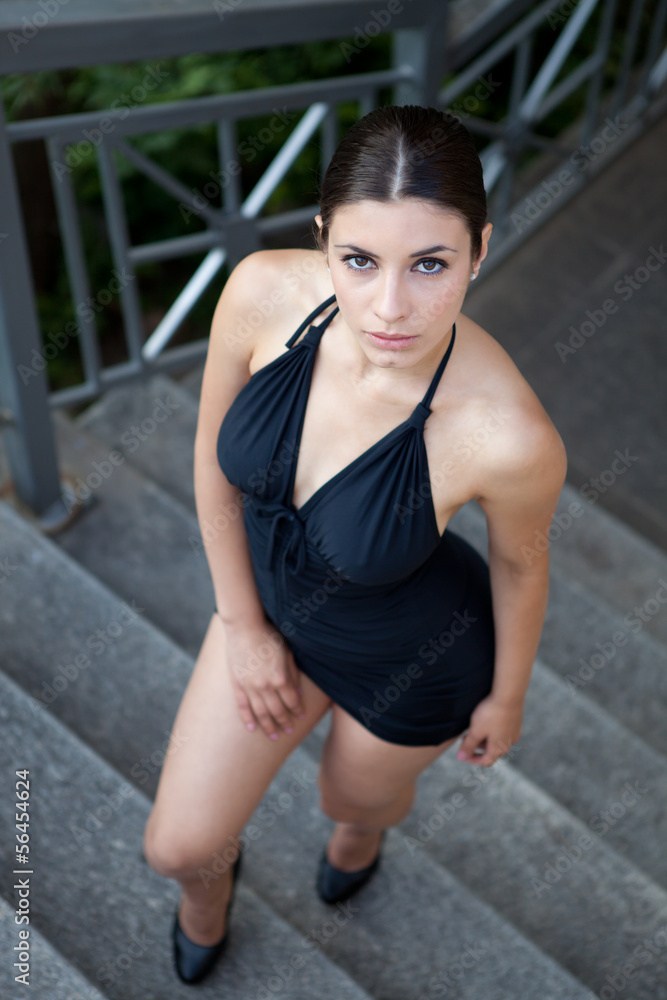 Young sexy woman with black dress posing outdoor