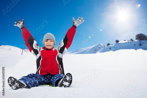 Happy boy sitting on sled on sunny day