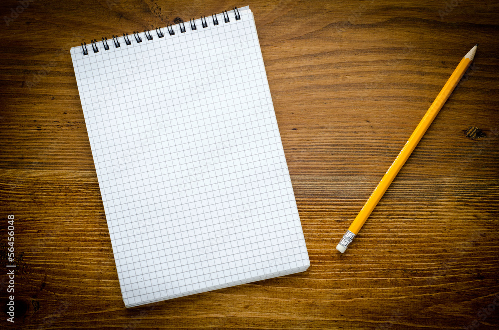 Black notebook with pencile on a wood background Black notebook with pencile on a wood background
