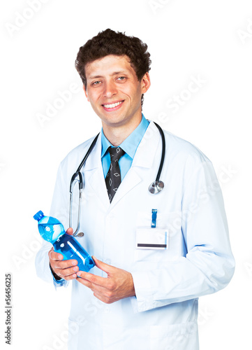 Portrait of a smiling male doctor holding bottle of water on whi