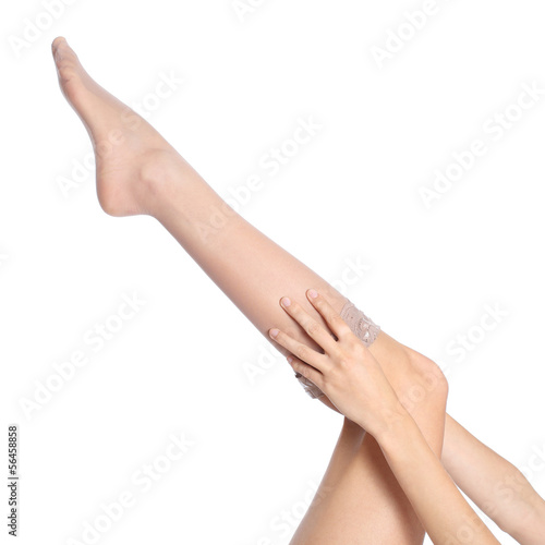 Woman hands putting a stockings on leg