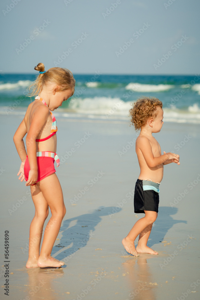 two happy kids playing at the beach in the day time two happy kids playing at the beach in the day time