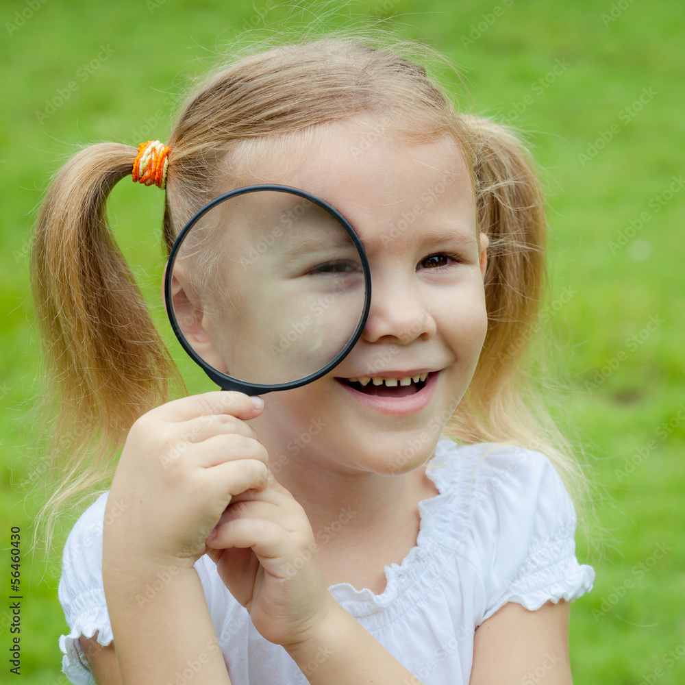 one little girl with magnifying glass outdoors in the day time one little girl with magnifying glass outdoors in the day time