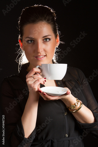 Portrait of beautiful woman posing in studio with cup of coffe