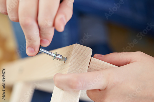 Hands assembling piece of furniture