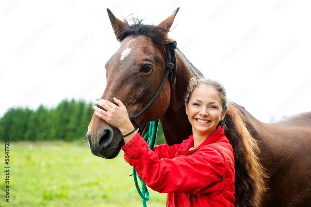 Obraz premium Beautiful smiling girl with her brown horse outdoors