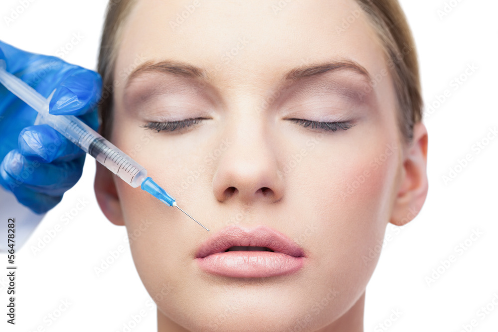 Close-up young woman receives cosmetic injection with syringe Close-up young woman receives cosmetic injection with syringe
