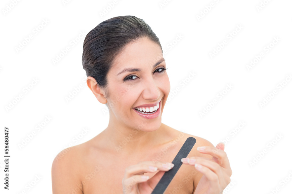 Pretty brunette filling her nails and smiling at camera Pretty brunette filling her nails and smiling at camera