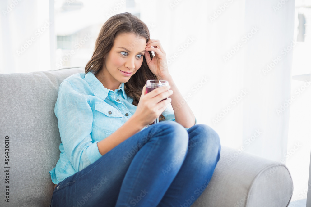 Funny woman looking at her glass of wine Funny woman looking at her glass of wine