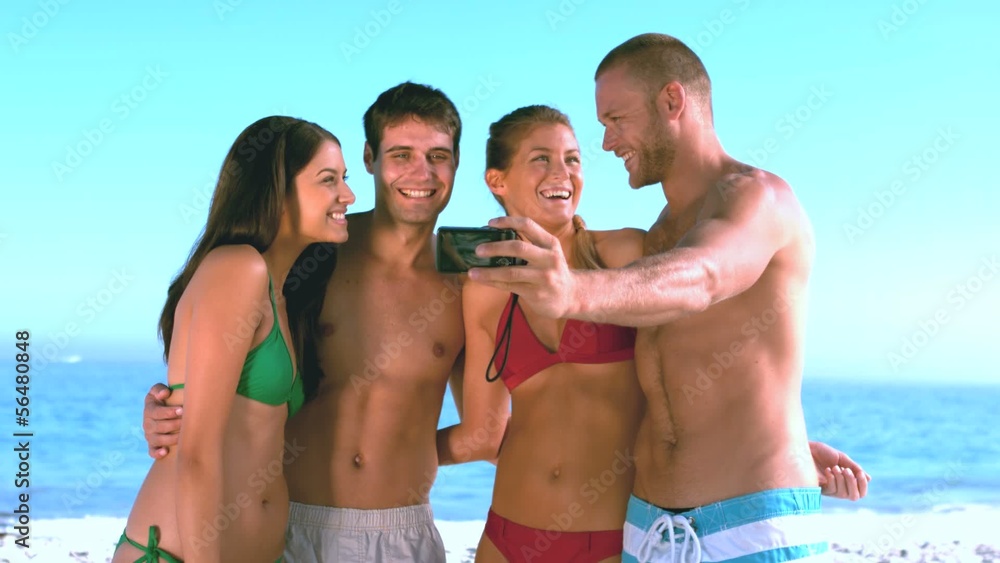 Group of friends taking self pictures on the beach Group of friends taking self pictures on the beach