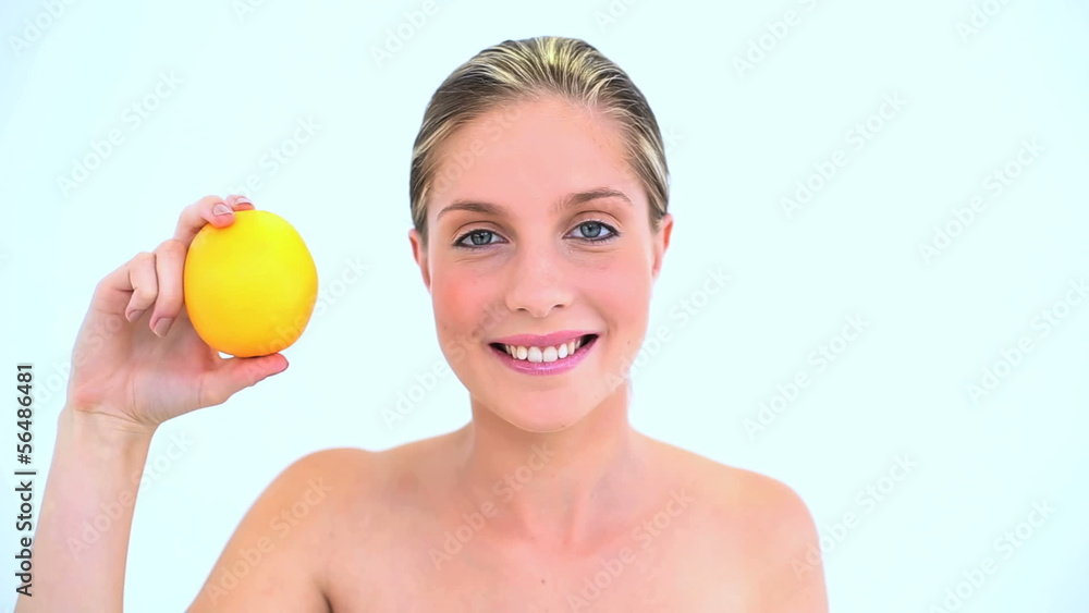 Cheerful woman holding an orange in her hand Cheerful woman holding an orange in her hand